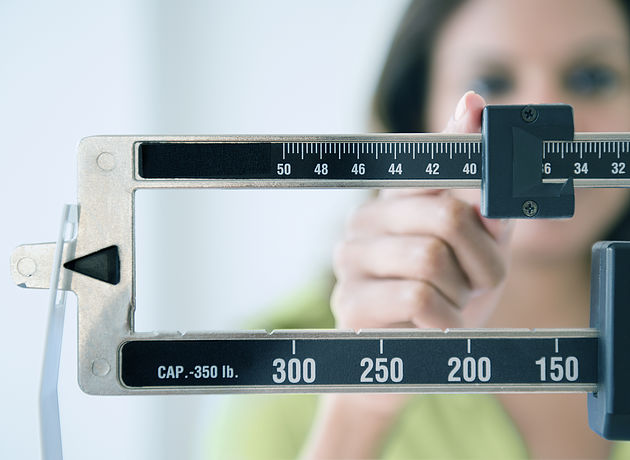 Cape Verdean woman weighing herself